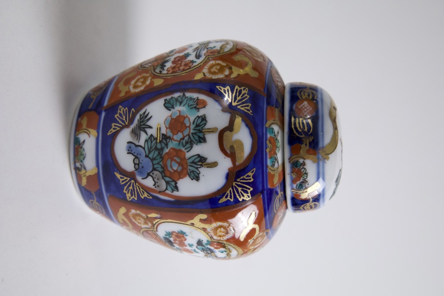 Dekorativ lockurna i porslin med polykrom dekor i rött, blått och guld i klassisk Imari-stil.