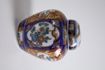Dekorativ lockurna i porslin med polykrom dekor i rött, blått och guld i klassisk Imari-stil.