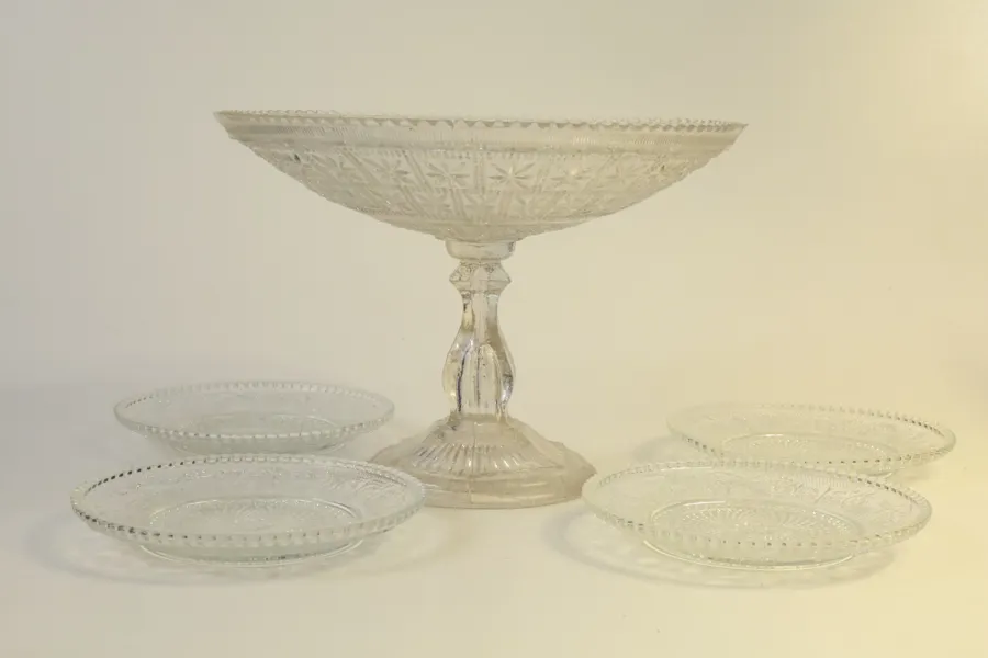 SKÅL PÅ FOT SAMT ASSIETTER, 5 delar, pressglas, 1900-talets första hälft.