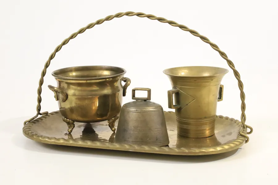 OBESTÄMD TILLVERKARE. SERVERINGSBRICKA MED TVÅ KÄRL OCH BORDSKLOCKA, MÄSSING OCH VITMETALL, 1900-TALETS FÖRSTA HÄLFT